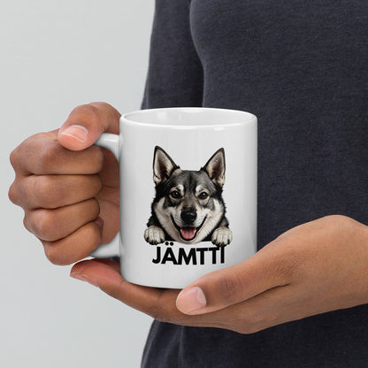 Mies pitelee käsissään jämtlanninpystykorva mukia, jossa jämttin kuva ja tumma teksti "jämtti".