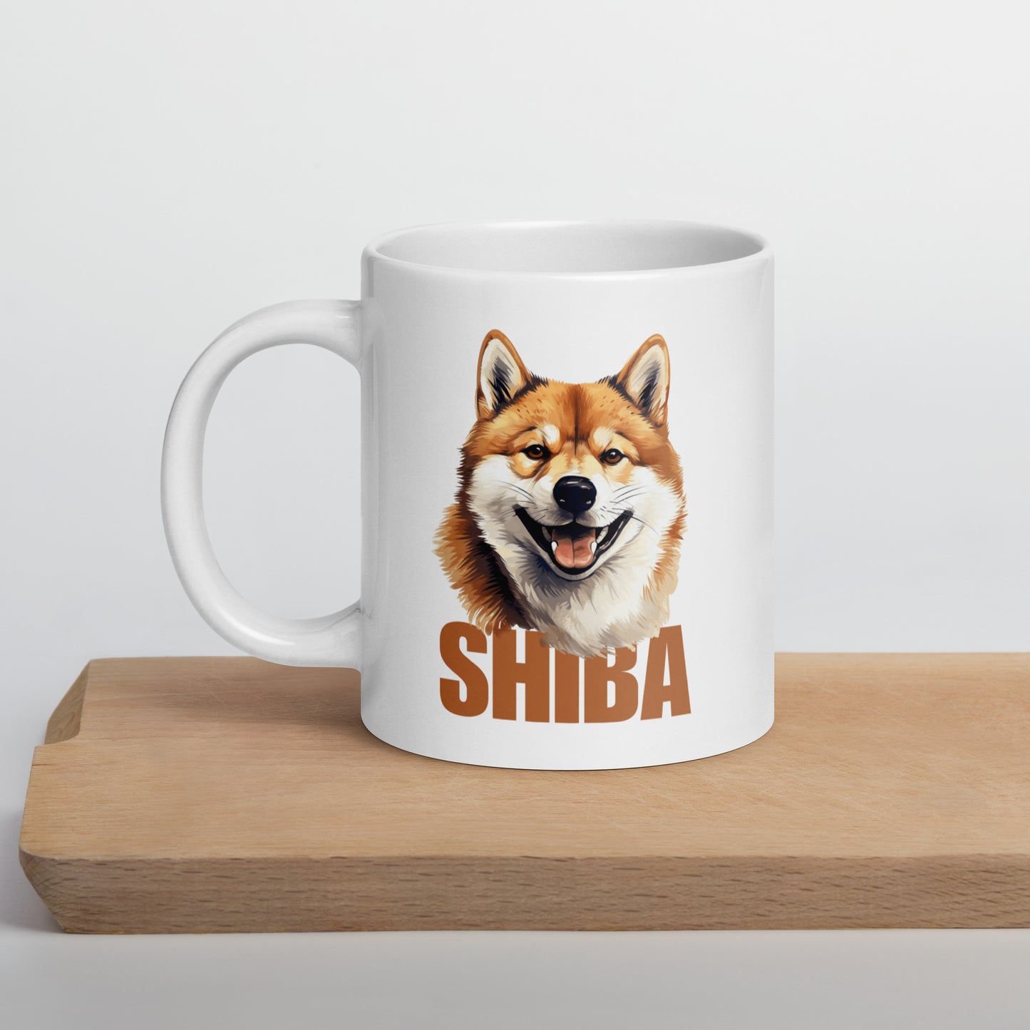 Pöydällä valkoinen muki, jossa shiba inu -koiran kuva ja ruskea teksti "shiba".